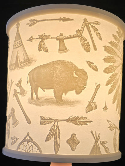 lampshade with a cylindrical white shade featuring buffalo and leaf patterns 